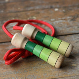 Mader Skipping Rope with Green Handles placed on a wooden board in the Babipur playroom. 