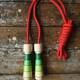 Mader Skipping Rope with Green Handles placed on a wooden board in the Babipur playroom. 