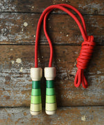 Mader Skipping Rope with Green Handles placed on a wooden board in the Babipur playroom. 