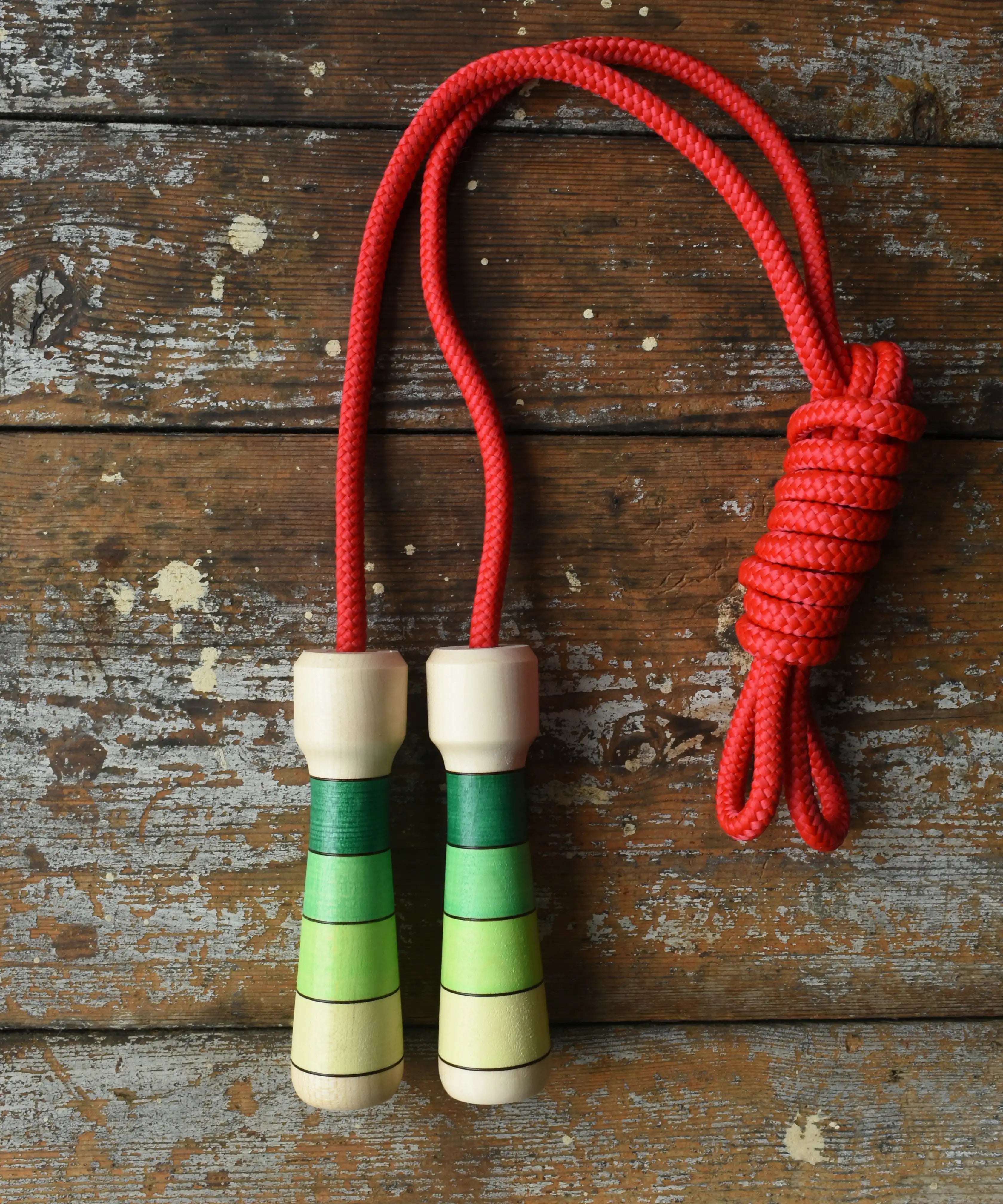 Mader Skipping Rope with Green Handles placed on a wooden board in the Babipur playroom. 