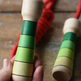 Mader Skipping Rope with Green Handles placed on a wooden board in the Babipur playroom. 