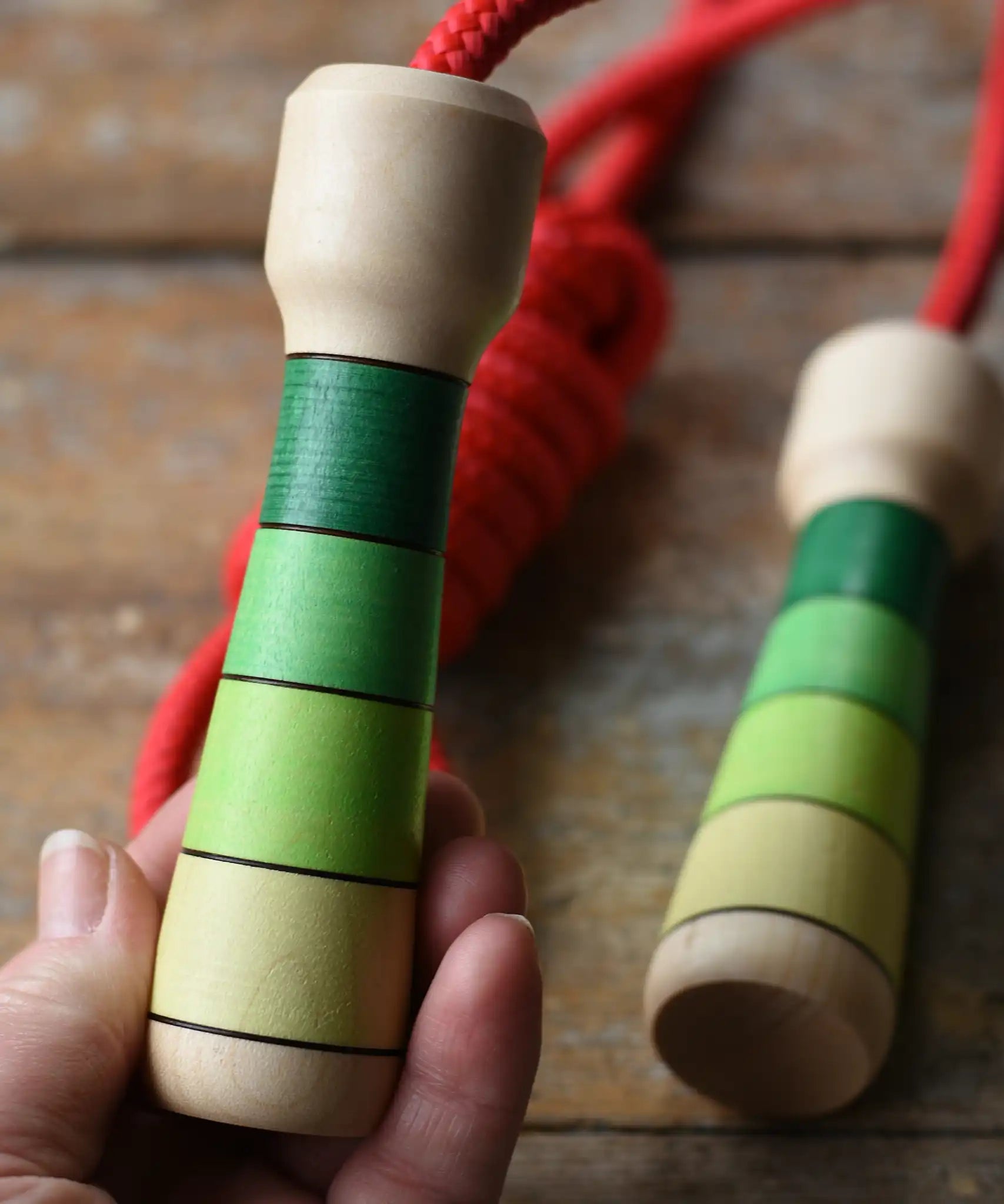 Mader Skipping Rope with Green Handles placed on a wooden board in the Babipur playroom. 