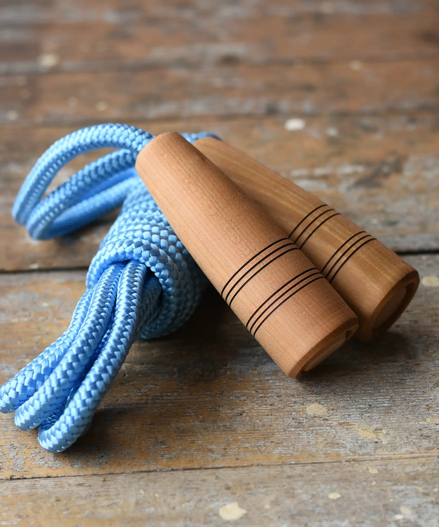 Mader Kreiselmanufaktur Children's Skipping Rope Natural Handles 5m length placed on a wooden surface in the Babipur playroom.