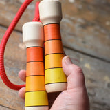 Mader Kreiselmanufaktur Children's Skipping Rope with Orange Handles in an adult's hand. 