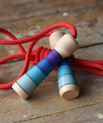 Mader Kreiselmanufaktur Children's Skipping Rope with Purple Handles placed on a wooden surface in the Babipur playroom. 