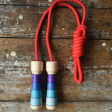 Mader Kreiselmanufaktur Children's Skipping Rope with Purple Handles placed on a wooden surface in the Babipur playroom. 
