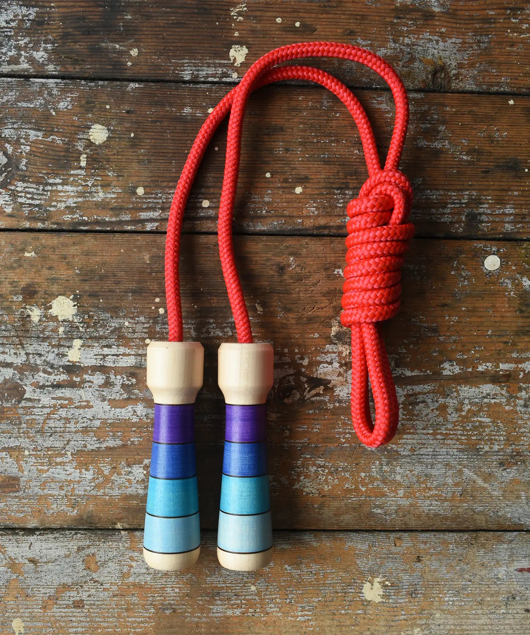 Mader Kreiselmanufaktur Children's Skipping Rope with Purple Handles placed on a wooden surface in the Babipur playroom. 