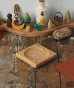 Mader Small Oak Spinning Plate placed on a wooden surface in the Babipur playroom.