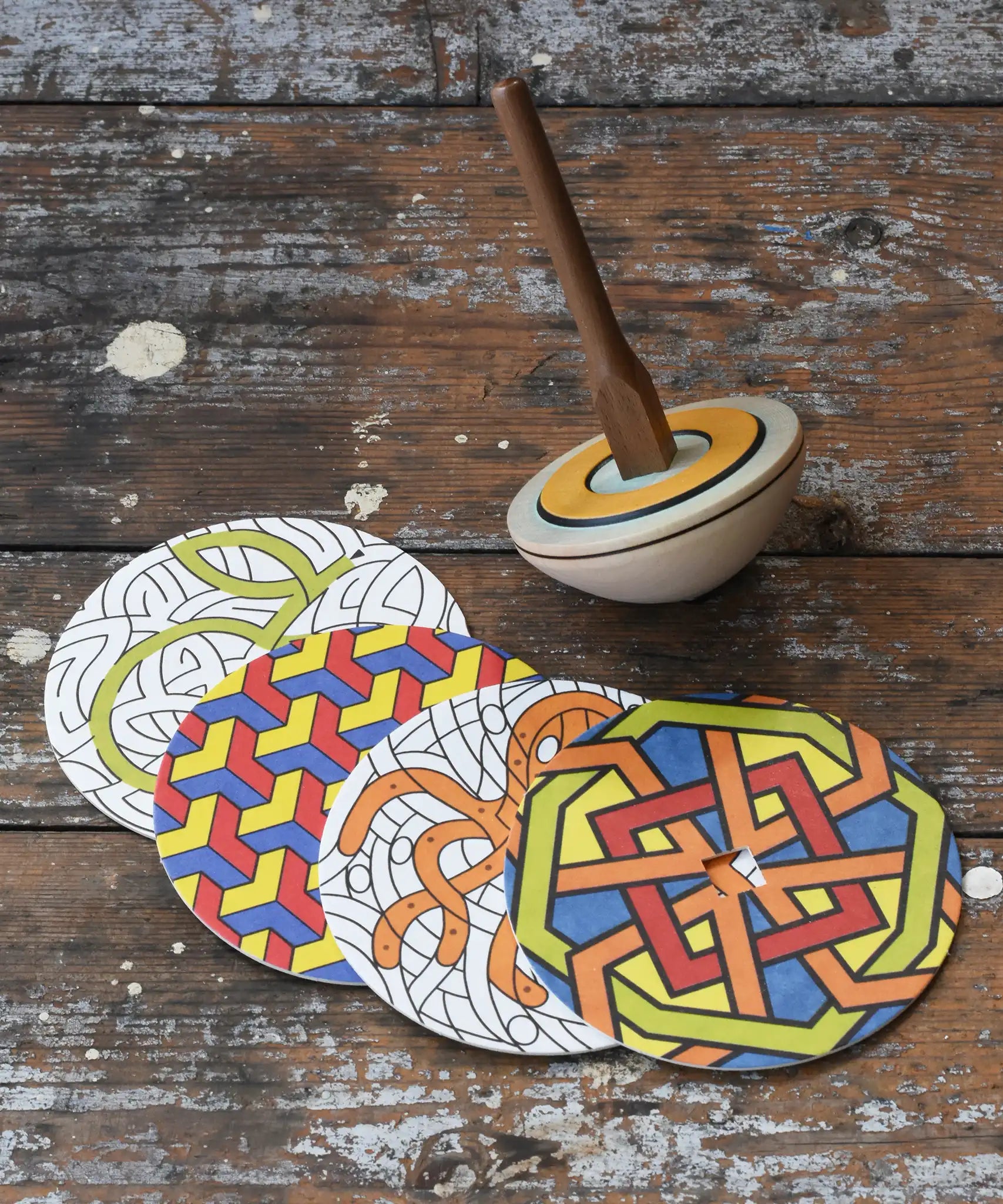 Mader 'So And So' DIY Spinning Top Set placed on a wooden desk in the Babipur playroom.