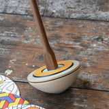 Mader 'So And So' DIY Spinning Top Set placed on a wooden desk in the Babipur playroom.
