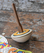 Mader 'So And So' DIY Spinning Top Set placed on a wooden desk in the Babipur playroom.