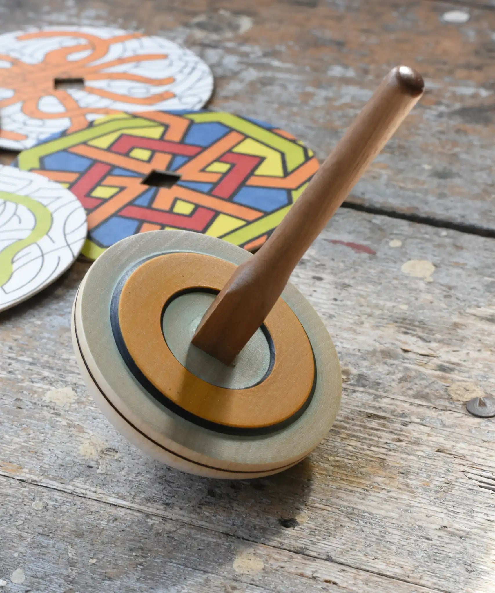 Mader 'So And So' DIY Spinning Top Set placed on a wooden desk in the Babipur playroom.