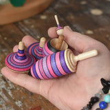 Mader lilac purple spinning top learning set in an adult's hand in the Babipur playroom. 