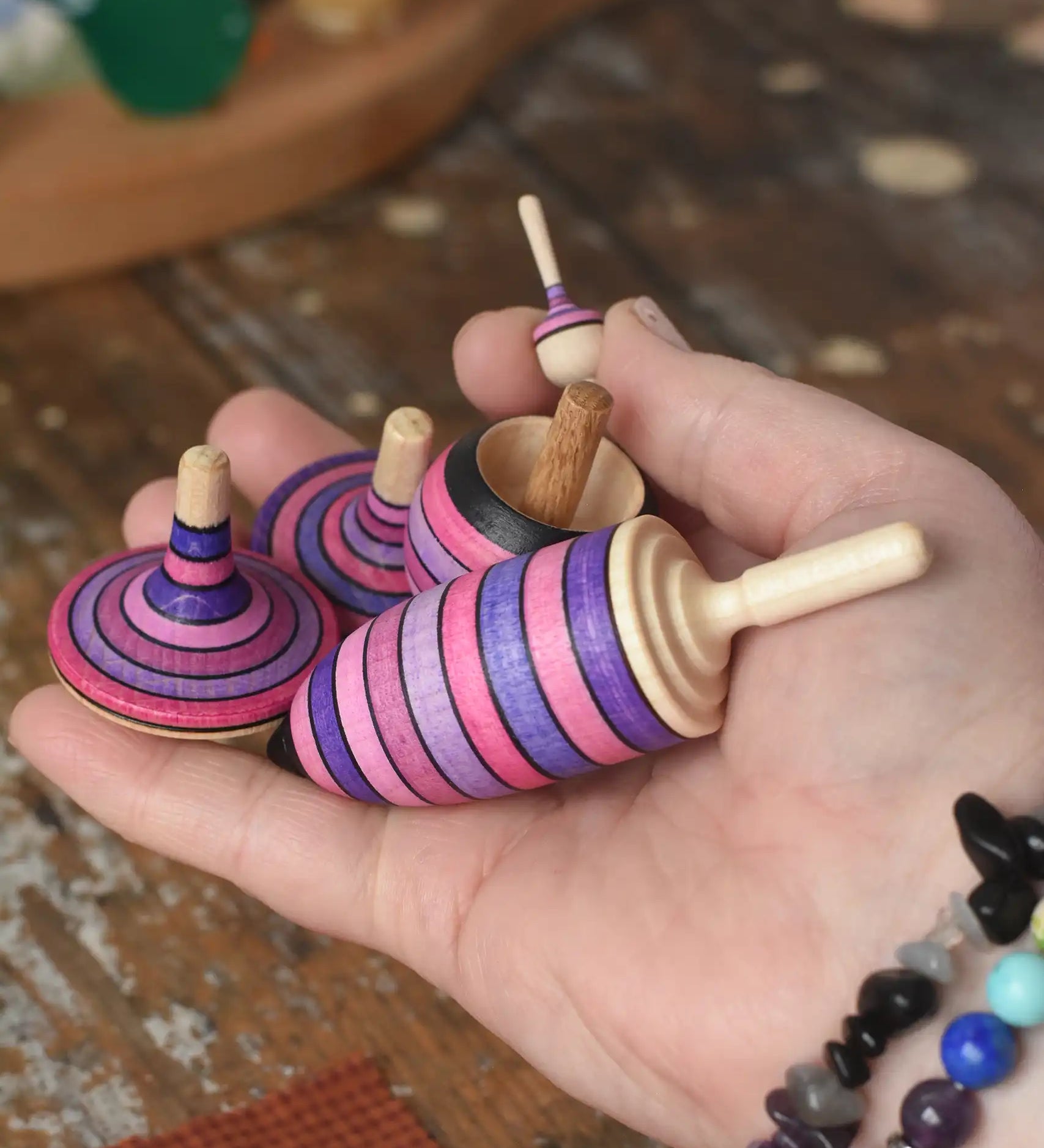 Mader lilac purple spinning top learning set in an adult's hand in the Babipur playroom. 