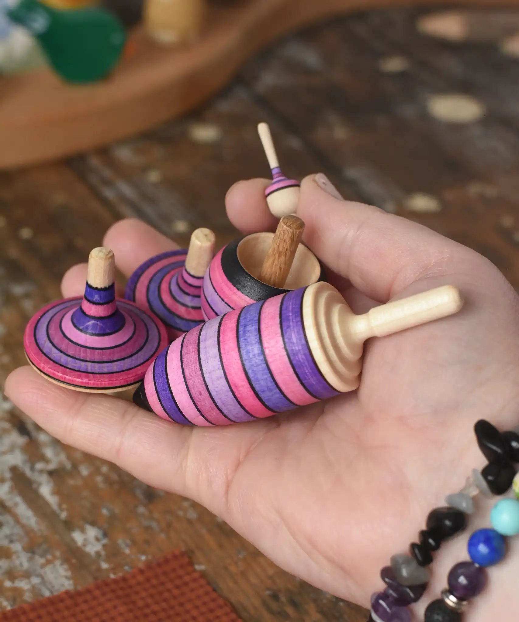 Mader lilac purple spinning top learning set in an adult's hand in the Babipur playroom. 
