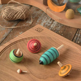 Mader Kreiselmanufaktur multicolour spinning top learning set placed on an oak spinning plate in the Babipur playroom. 