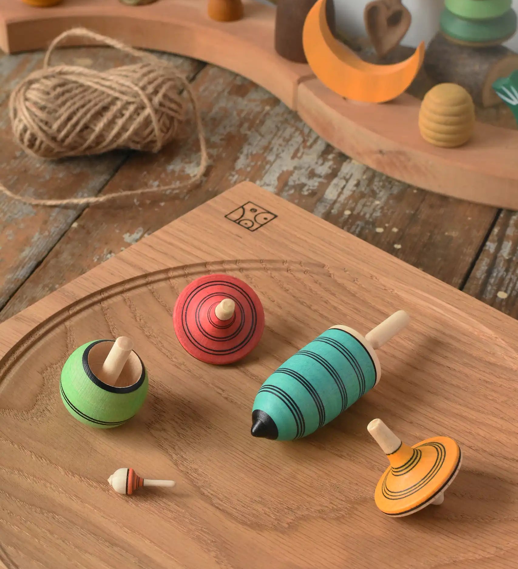 Mader Kreiselmanufaktur multicolour spinning top learning set placed on an oak spinning plate in the Babipur playroom. 