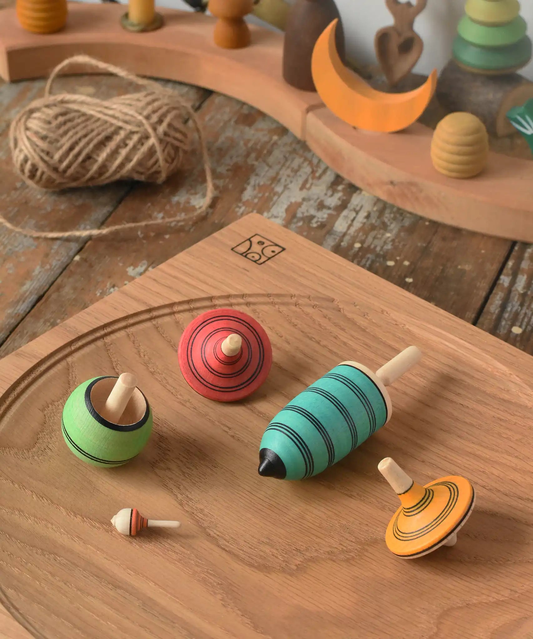 Mader Kreiselmanufaktur multicolour spinning top learning set placed on an oak spinning plate in the Babipur playroom. 