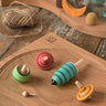 Mader Kreiselmanufaktur multicolour spinning top learning set placed on an oak spinning plate in the Babipur playroom. 