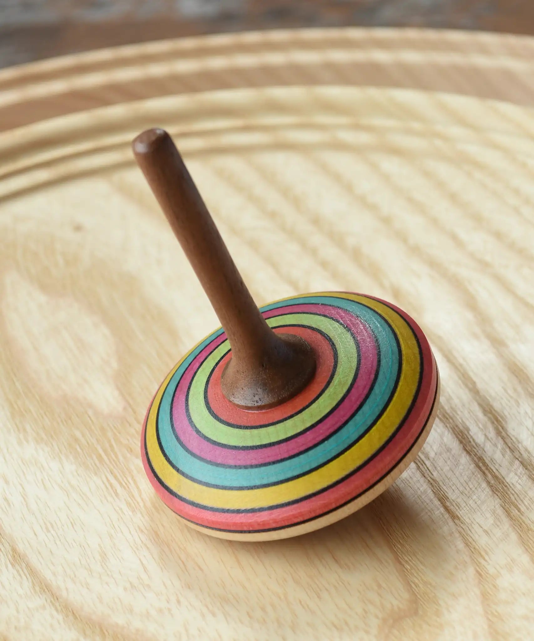 Mader stripe spinning top placed on a spinning plate. 