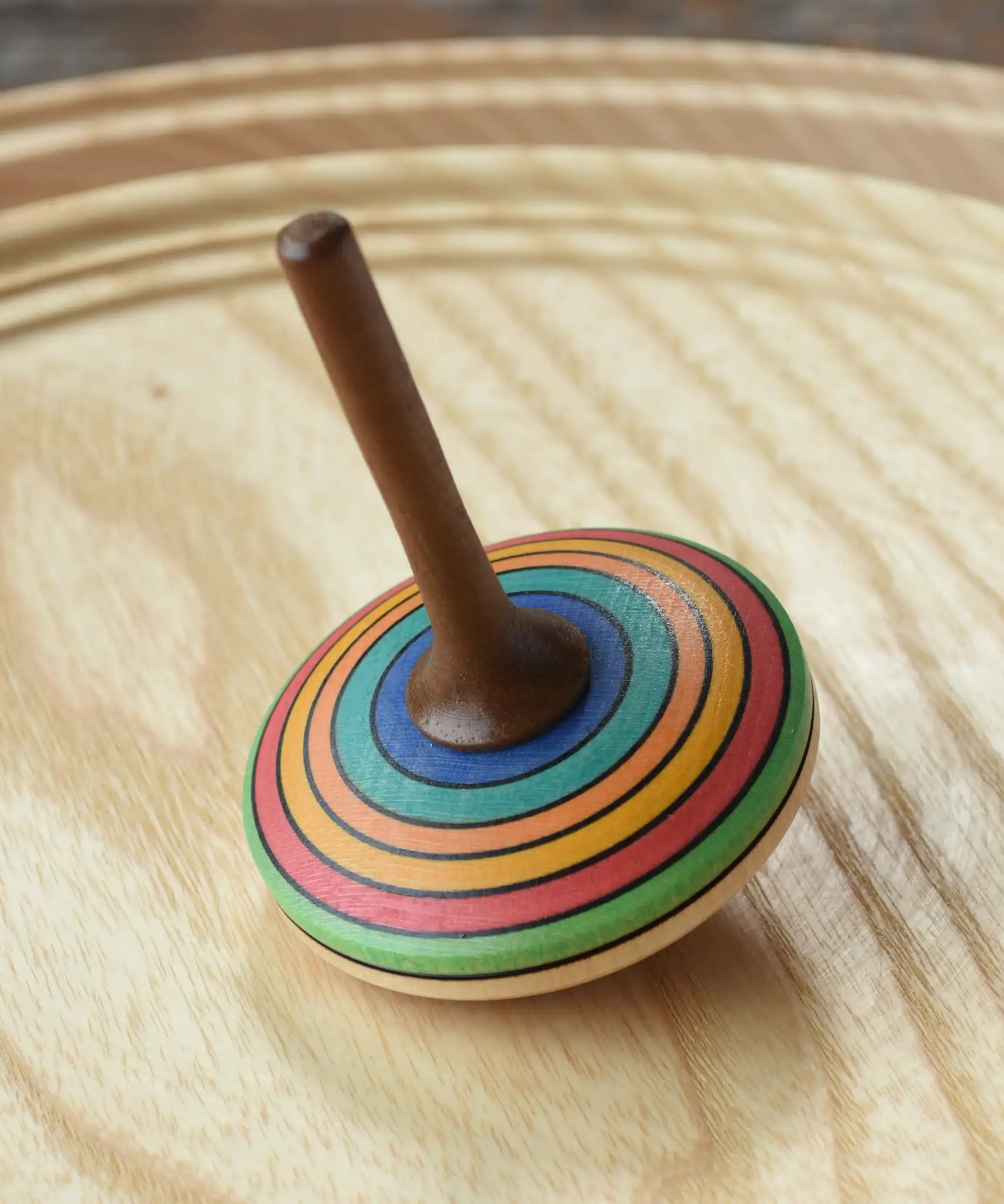 Mader stripe spinning top placed on a spinning plate. 