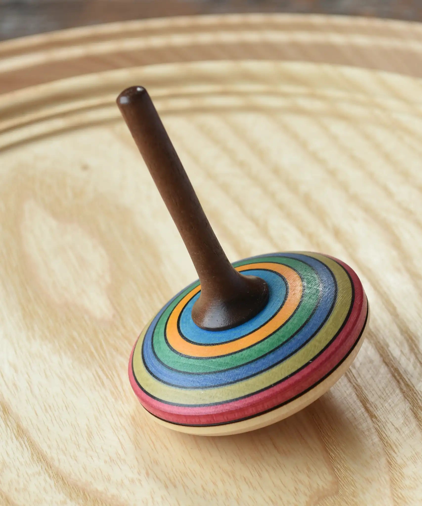 Mader stripe spinning top placed on a spinning plate. 