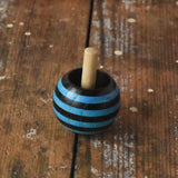 Blue striped Mader tango turn-over spinning top placed on a wooden desk in the Babipur playroom. 