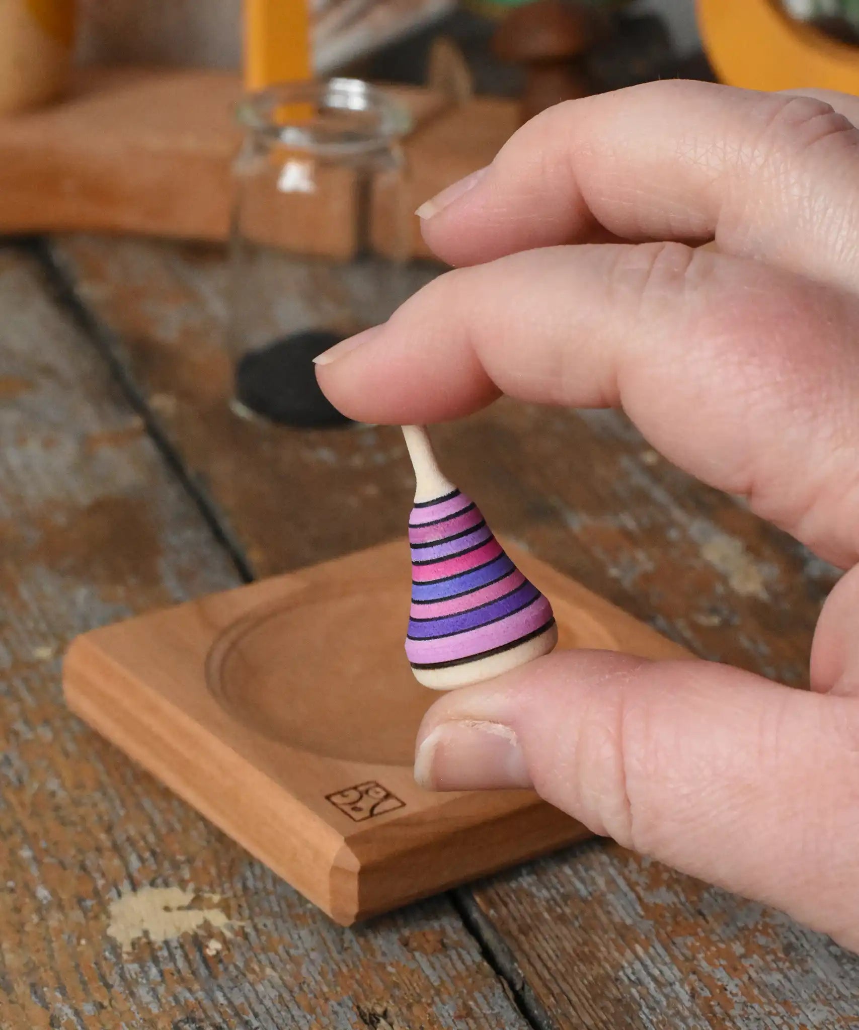 Mader Tarantella On Stage mini spinning top in an adult hand in the Babipur playroom. 