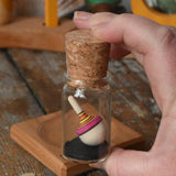 Mader Tarantella On Stage mini spinning top in an adult hand in the Babipur playroom. 