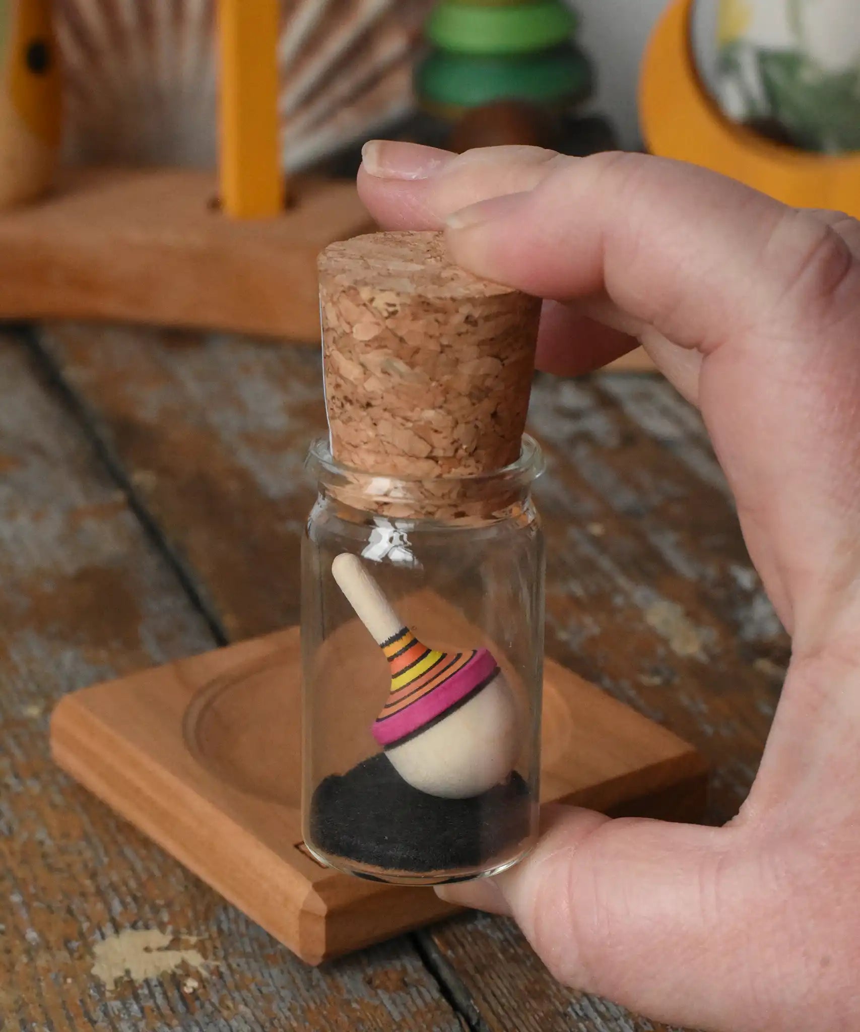 Mader Tarantella On Stage mini spinning top in an adult hand in the Babipur playroom. 