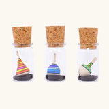 Three Mader tarantella spinning tops in their glass cork topped storage jars.