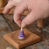 Mader Tarantella On Stage mini spinning top in an adult hand in the Babipur playroom. 