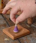 Mader Tarantella On Stage mini spinning top in an adult hand in the Babipur playroom. 