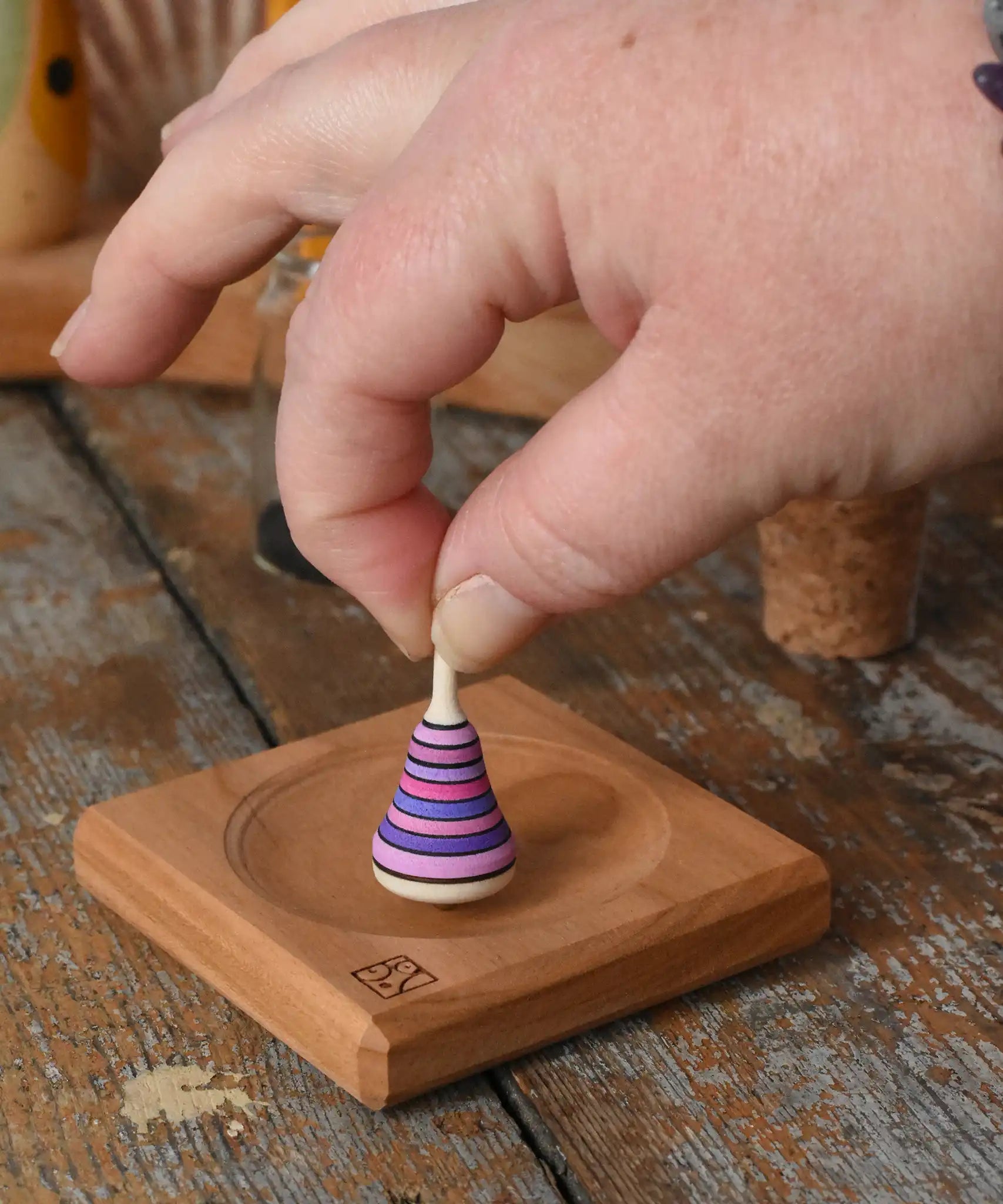 Mader Tarantella On Stage mini spinning top in an adult hand in the Babipur playroom. 
