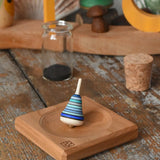Mader Tarantella On Stage mini spinning top and plate set placed on a desk in the Babipur playroom. 
