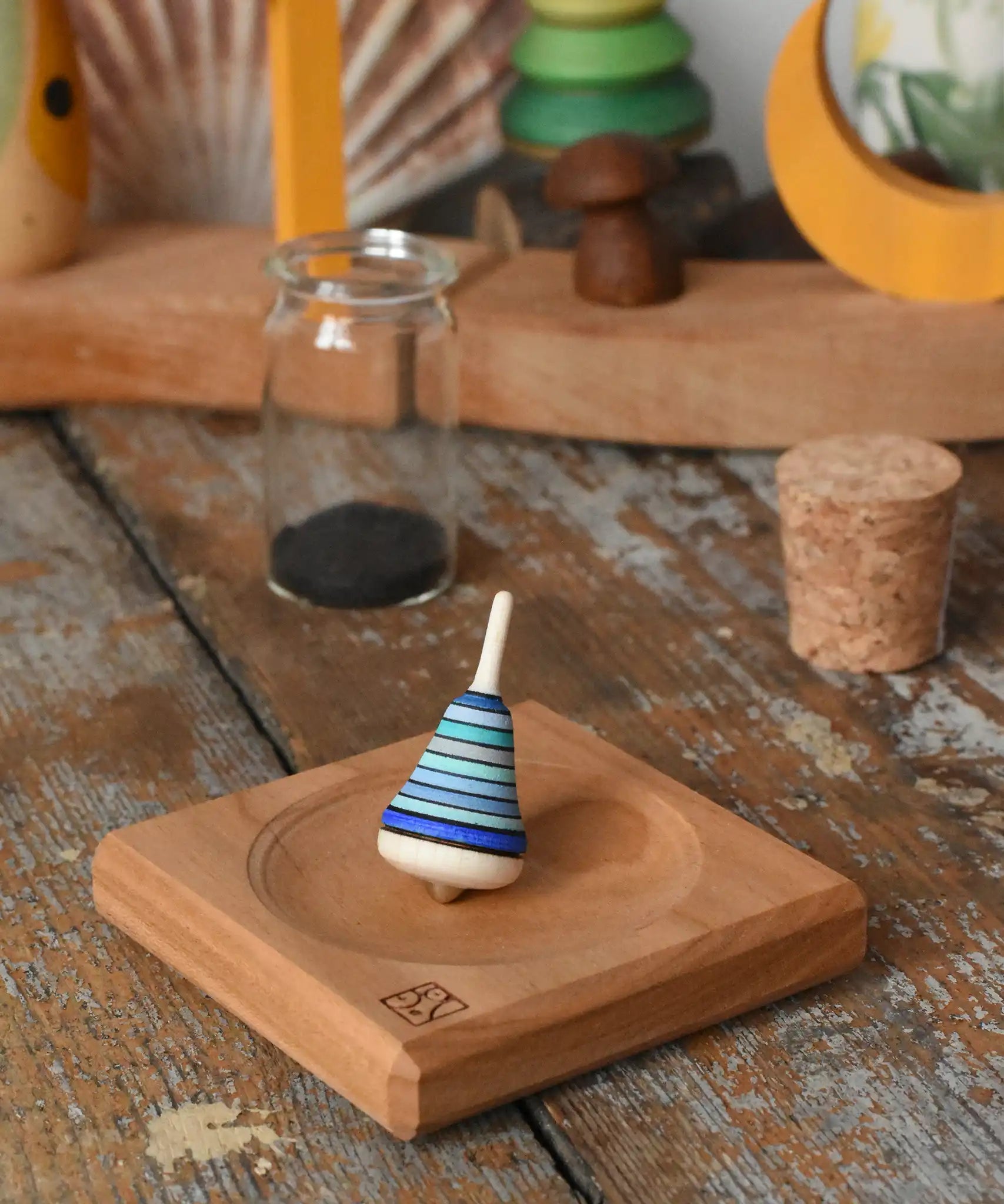 Mader Tarantella On Stage mini spinning top and plate set placed on a desk in the Babipur playroom. 