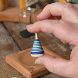 Mader Tarantella On Stage mini spinning top in an adult hand in the Babipur playroom. 