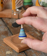 Mader Tarantella On Stage mini spinning top in an adult hand in the Babipur playroom. 