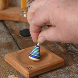 Mader Tarantella On Stage mini spinning top and plate set placed on a desk in the Babipur playroom. 