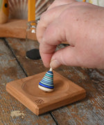 Mader Tarantella On Stage mini spinning top and plate set placed on a desk in the Babipur playroom. 