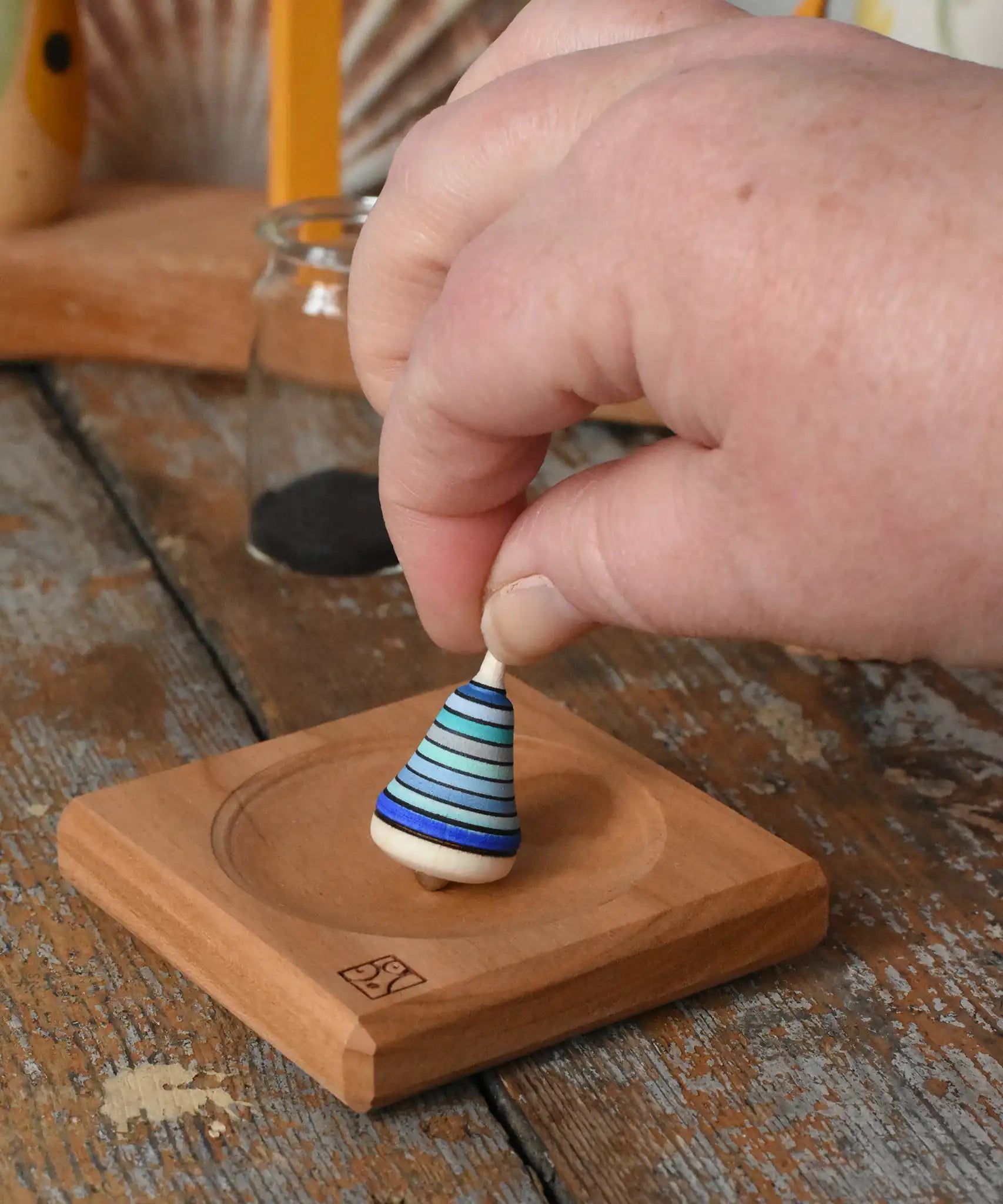 Mader Tarantella On Stage mini spinning top and plate set placed on a desk in the Babipur playroom. 