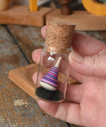 Mader Tarantella On Stage mini spinning top in an adult hand in the Babipur playroom. 