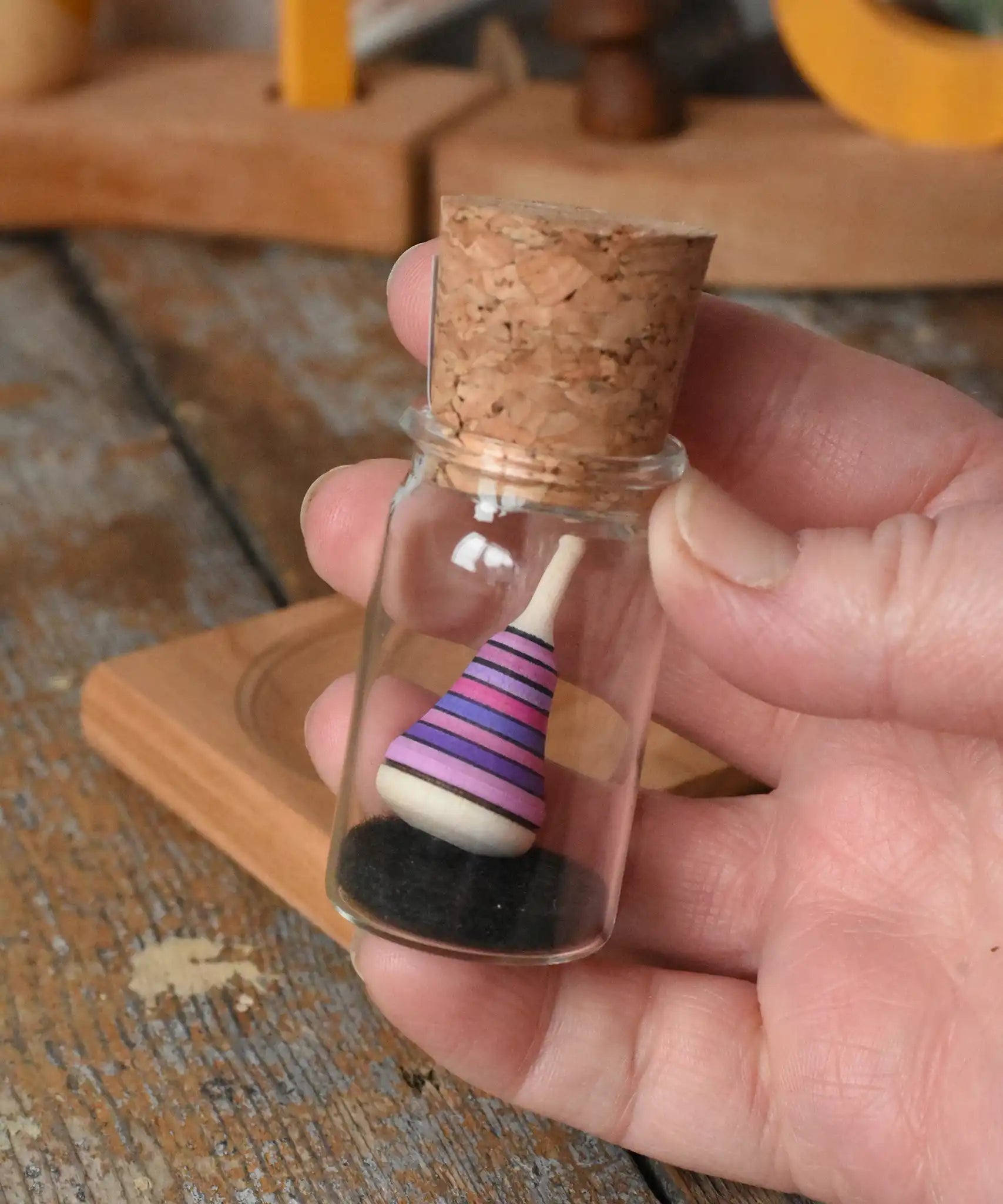 Mader Tarantella On Stage mini spinning top in an adult hand in the Babipur playroom. 