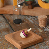 Mader Tarantella On Stage mini spinning top and plate set placed on a desk in the Babipur playroom. 