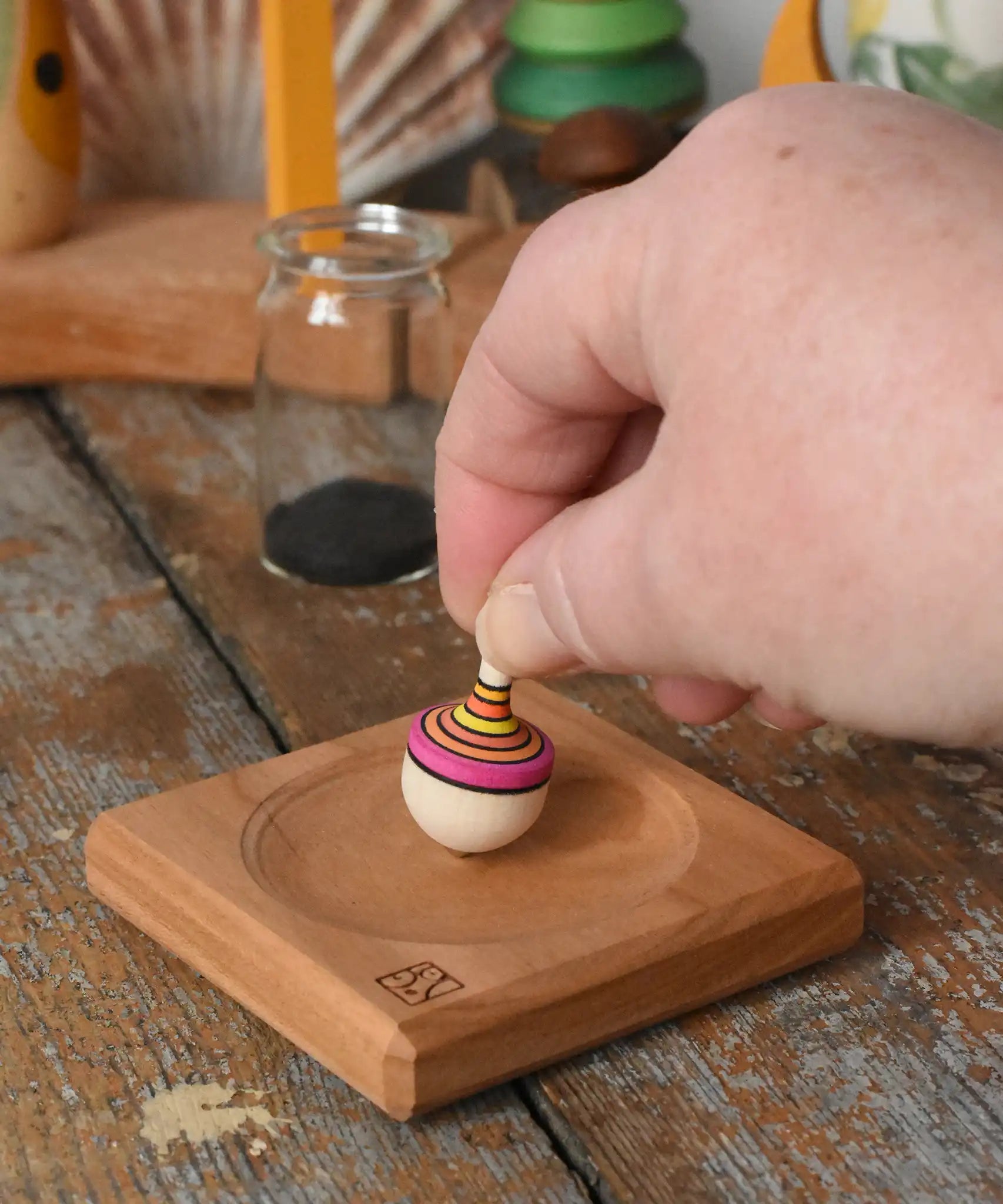 Mader Tarantella On Stage mini spinning top in an adult hand in the Babipur playroom. 