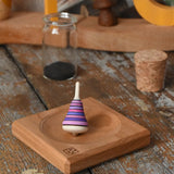 Mader Tarantella On Stage mini spinning top and plate set placed on a desk in the Babipur playroom. 