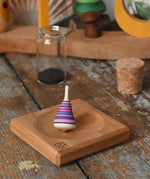 Mader Tarantella On Stage mini spinning top and plate set placed on a desk in the Babipur playroom. 