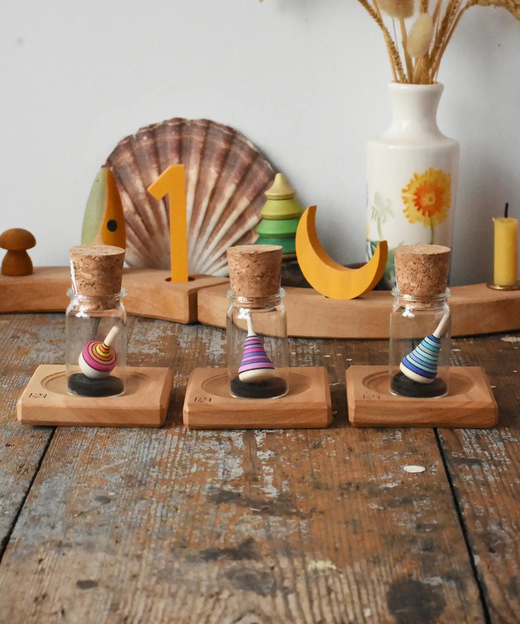 Three Mader Tarantella On Stage mini spinning top and plate set placed on a desk in the Babipur playroom. 