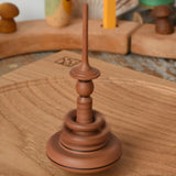 Mader Helene's Captive Rings Apple Spinning Top spinning in motion on an oak spinning plate in the Babipur playroom.