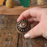 Mader orient turn-over spinning top shown in an adult's hand.